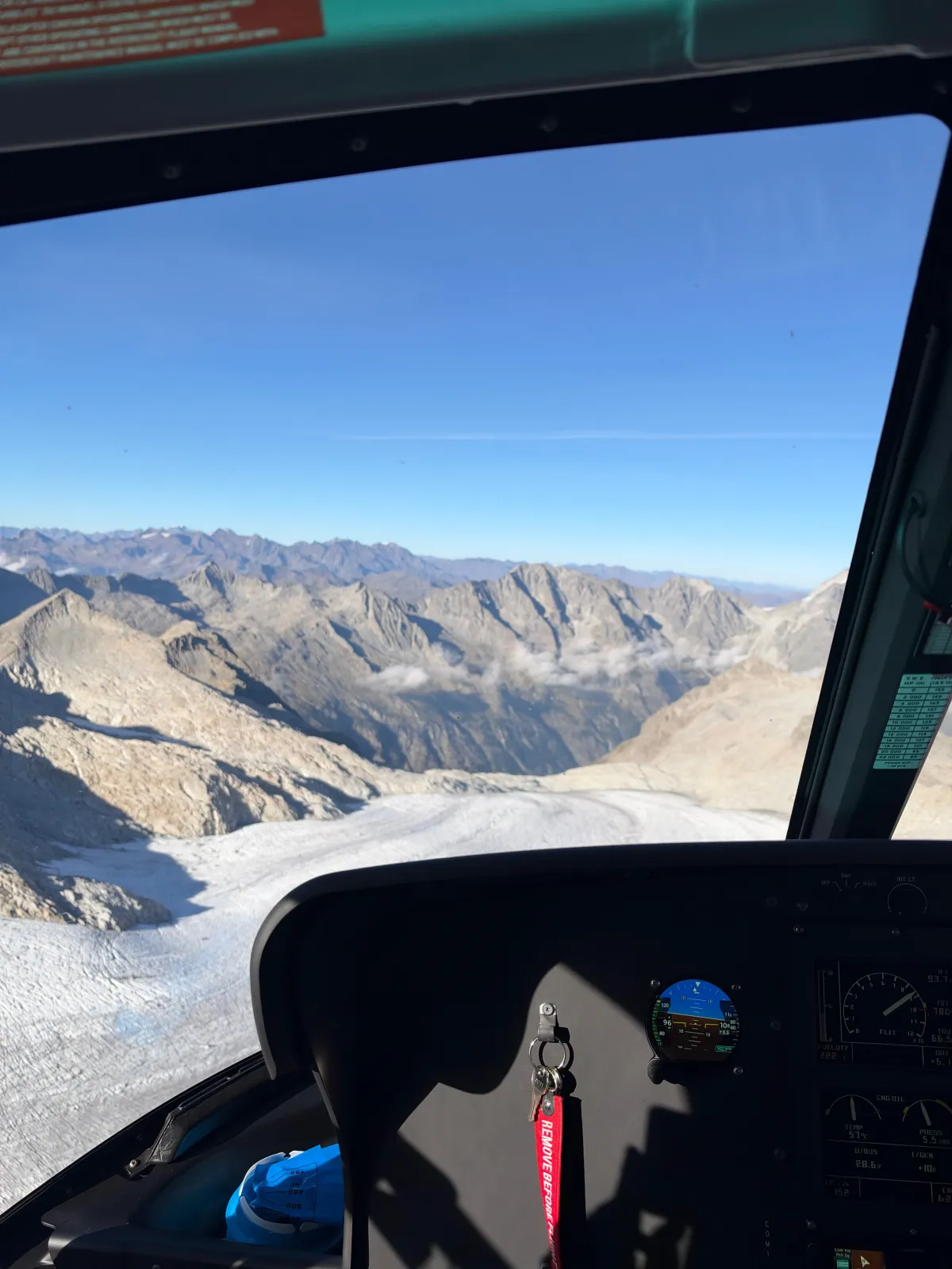 Il ghiacciaio dell'Adamello visto dal parabrezza dell'elicottero, con la strumentazione di bordo in primo piano